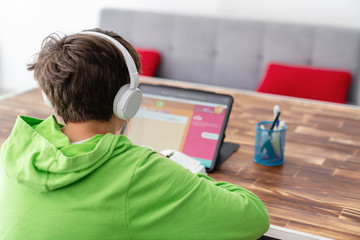 young boy is studying in front of the laptop. e learning, study at home online.