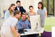 © JackF - Positive young business men and women at teamwork around computer monitor