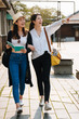 © PR Image Factory - two asian chinese travel girl friends walking around old city area on summer vacation with guide book having fun. full length laughing young women friends showing aside while relax outdoor sunny day