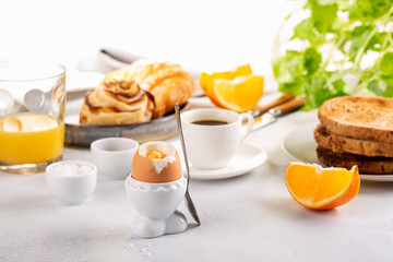 Wall Mural - Delicious breakfast with soft boiled eggs, toasted bread, cup of coffee and orange juice.