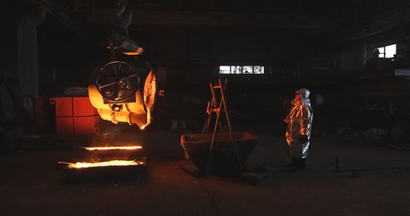 Wall Mural - Smelting orange metal in a metallurgical plant. Liquid iron from the ladle