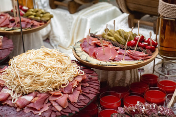 Wall Mural - Сheese, cold meats, sliced sausages, cucumbers, tomatoes and fresh red juice on a festive table. Variety of tasty delicious snacks. Food concept