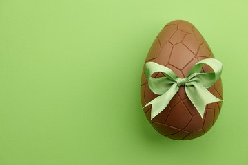 Wall Mural - Chocolate Easter egg with green ribbon bow