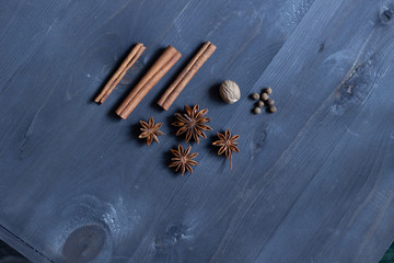 Sticker - Star anise, cinnamon sticks, nutmeg, allspice  on black wooden background