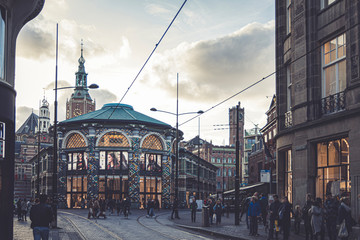 old town, end of the boulevard full of shops and shopping people. there is a tram and a new sky