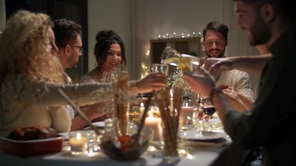 Poster - holidays, food and people concept - happy smiling friends having christmas dinner and eating at home in evening