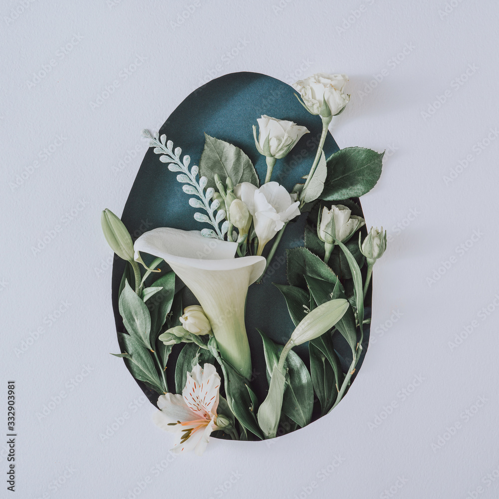 Creative Easter layout with flowers and leaves on white paper background. Spring nature Easter holiday minimal concept. Egg shape flat lay. - obrazy, fototapety, plakaty 