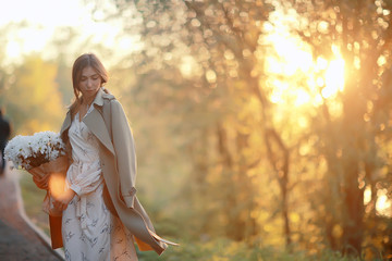 girl holding a bouquet of flowers a walk in the park / romantic young beautiful cute model, love feelings gift