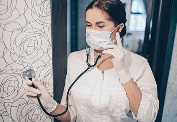 Woman doctor nurse wearing protective mask and stethoscope for check breathing, corona virus prevention, hygiene to stop spreading coronavirus. Avoid contaminating Corona virus Covid-19 concept