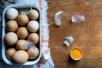 Wall Mural - Broken chicken egg close up. Protein and yolk. Tray with chicken eggs.