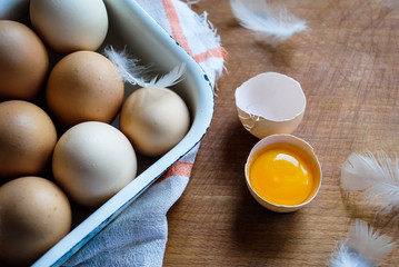 Wall Mural - Chicken eggs lie in a bowl on the table. Broken egg, yolk and protein