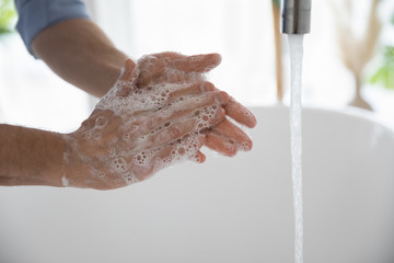  Close up of man wash clean hands with antibacterial soap protect from corona virus pandemic, person use sanitizer, take care of hygiene, stop covid-19 coronavirus outbreak, healthcare concept