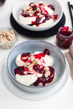 Fototapeta Tulipany - Cottage cheese pancakes with cherry sauce, sour cream and caramelized nuts on white table.