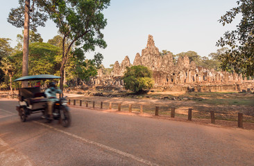 Wall Mural - Motion blur from autorickshaw driving past the 12th century Bayon temple, Cambodia. Historical landmark in Angkor. UNESCO world heritage site