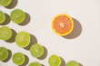 Sliced lime fruits with orange on light background, flat design