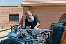 Retired Senior Man With His Antique Car Tweeking His Engine