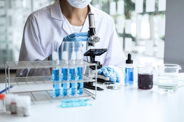 Biochemistry laboratory research, Chemist is analyzing sample in laboratory with Microscope equipment and science experiments glassware containing chemical liquid