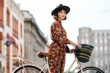 Stylish Woman In Floral Dress With Bicycle In The City