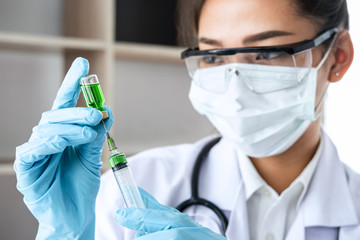 Doctor hand holding syringe and vaccine in blue gloves to prepare prevent pandemic of the disease, flu or influenza virus