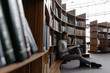 © Milles Studio/Stocksy - Focused young woman with book in library