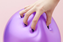 Woman's Hand About To Burst Balloon With Fingernails