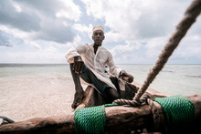 Portrait Of Fisherman Sitting In Boat By Sea
