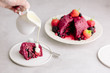 © Gourmet Photography/Stocksy - Pouring cream onto Summer Pudding, classic English dessert