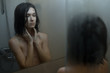 © ZHPH Production by Artem Zhushman/Stocksy - Woman in shower looking at mirror