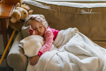 Little Girl Sleeping On Couch With Hobby Horse