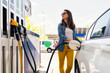 © Santi Nunez/Stocksy - Beautiful woman filling the car's tank