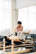 © MaaHoo Studio/Stocksy - Pregnant woman practicing pilates with equipment reformer