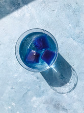 Glass Of Water With Blue Ice Cubes