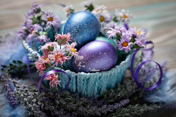 Wall Mural - Happy Easter. Congratulatory easter background. Easter eggs and flowers. Background with copy space. Selective focus. Top view.