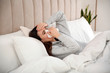 © New Africa - Sick young woman in bed at home. Influenza virus