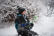 Young Boy Making Snowball With Snowball Making Toy On Winter Day.