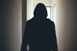 Silhouette of a man sneaking through the hallway of a house