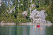 © Cavan Images - Rear view of retired woman paddling a packraft on remote lake.