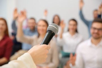 Wall Mural - Business trainer with microphone answering questions indoors, closeup