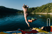 From Behind A Woman Jumps Into A Lake From A Dock