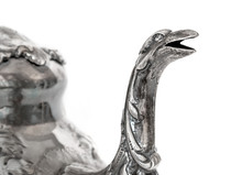Vintage Tea Spout. Close Up Of Antique Sterling Silver Tea Pot. Spout Is A Creature With Open Mouth, Possible Snake Or Dragon. Repousse Tea Pot Body. Sterling Silver. Isolated On White.
