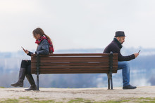 Man And Woman Sitting Apart On A Bench