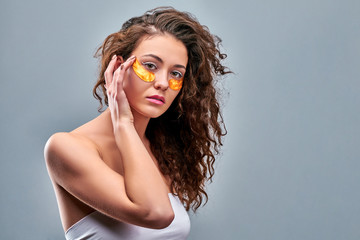 beauty portrait of an attractive girl with a gold patch under the eye.