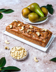 Wall Mural - Homemade rustic chocolate cake with pear and cashew nuts,top view