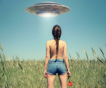 A Girl In The Field Watching A UFO In The Sky. Fiction Scene With Alien Spaceship. Photo With 3d Rendering Element