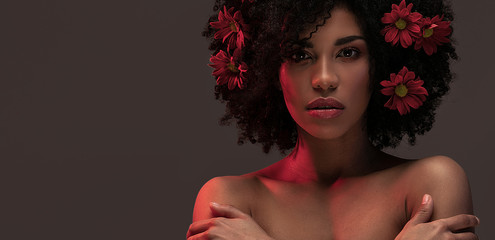 Beauty afro girl with flowers in hair.