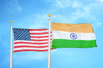 United States and India two flags on flagpoles and blue cloudy sky