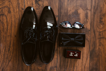 black shoes, glasses, bows and cuffs on the floor of the room