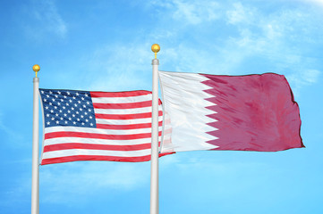 United States and Qatar two flags on flagpoles and blue cloudy sky