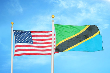 United States and Tanzania two flags on flagpoles and blue cloudy sky