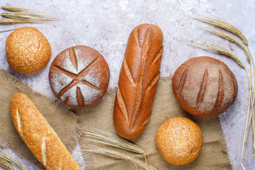 Wall Mural - Different kinds of fresh bread as background, top view